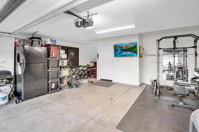 garage featuring a garage door opener and stainless steel fridge