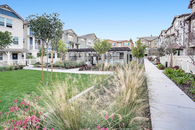 view of home's community featuring a lawn and a pergola