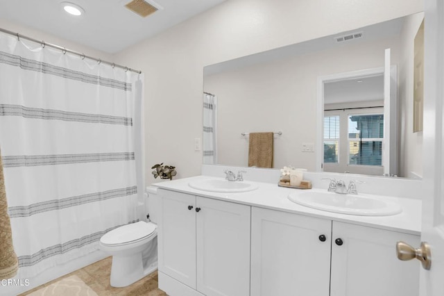 bathroom with toilet, tile patterned floors, and vanity