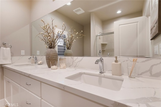 bathroom featuring a shower with shower door and vanity