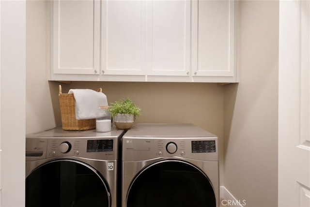 laundry room with independent washer and dryer and cabinets