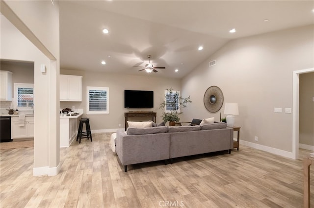 living room with ceiling fan, light hardwood / wood-style floors, lofted ceiling, and a fireplace