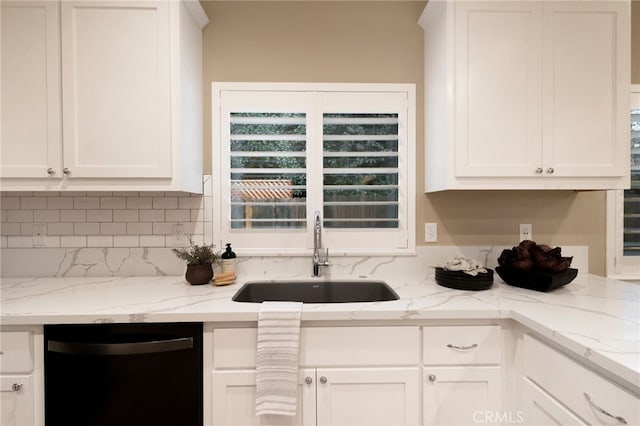 kitchen featuring light stone countertops, sink, white cabinetry, and dishwasher