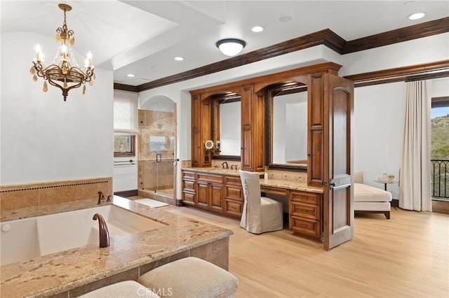 bathroom featuring hardwood / wood-style flooring, shower with separate bathtub, vanity, and an inviting chandelier