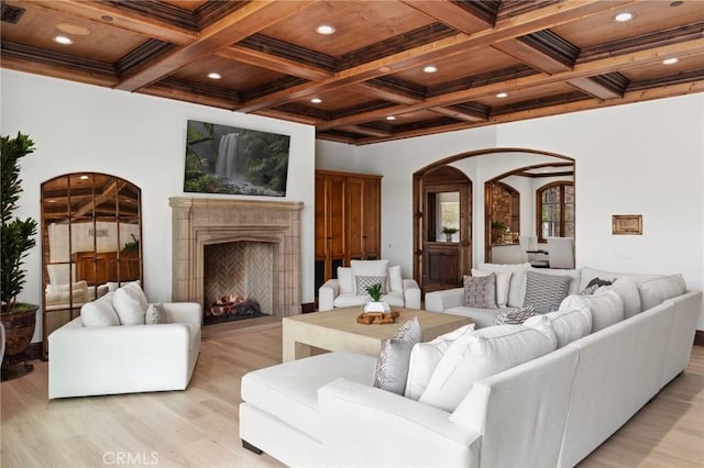 living room featuring beam ceiling, light wood-type flooring, wood ceiling, and coffered ceiling