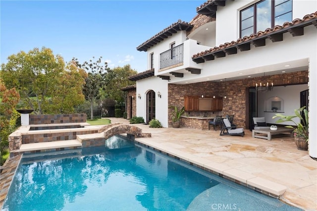 rear view of property with an outdoor fireplace and a patio