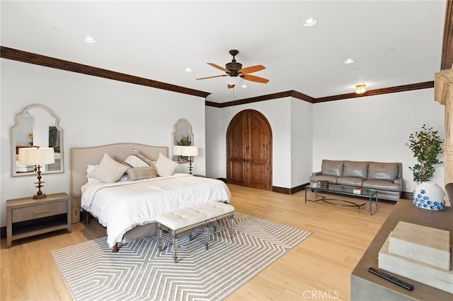 bedroom featuring ceiling fan, light hardwood / wood-style floors, and crown molding