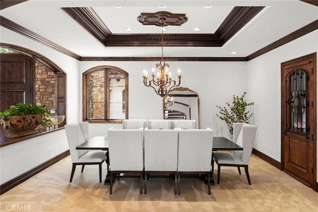 dining room with an inviting chandelier, ornamental molding, and a tray ceiling