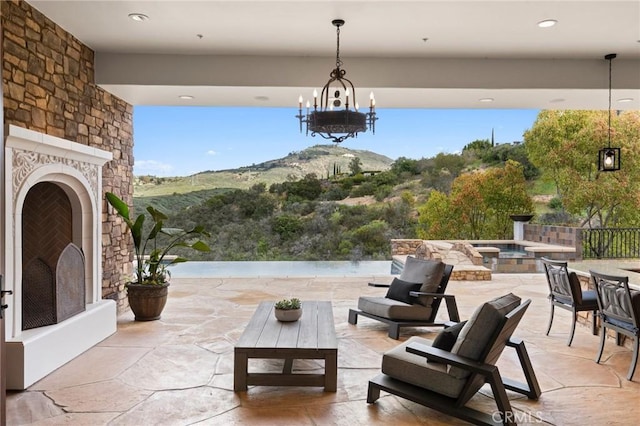 view of patio / terrace featuring an outdoor stone fireplace and a mountain view