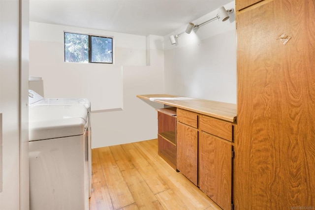 kitchen featuring light hardwood / wood-style flooring, track lighting, and washing machine and clothes dryer