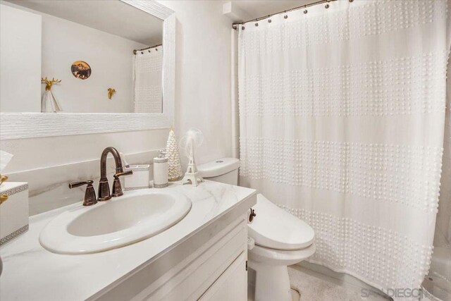 bathroom with toilet, a shower with curtain, and vanity