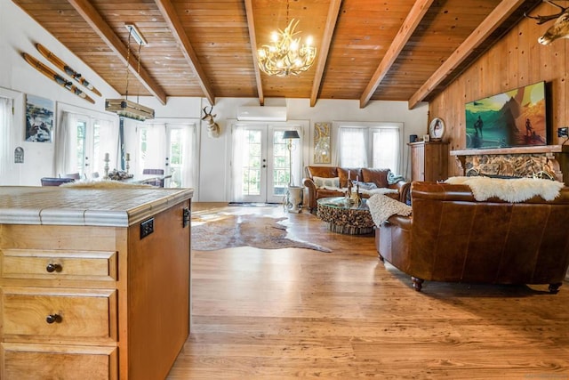 living room featuring wood ceiling, a chandelier, french doors, and light hardwood / wood-style floors