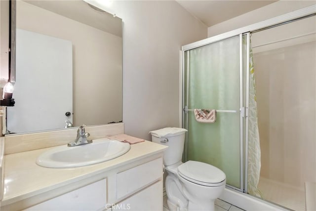 bathroom with toilet, tile patterned flooring, walk in shower, and vanity