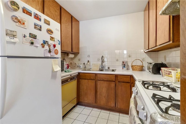 kitchen featuring tasteful backsplash, light tile patterned floors, sink, and white appliances