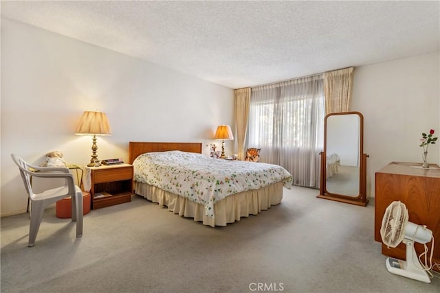 bedroom with light colored carpet and a textured ceiling