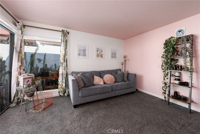 living room featuring dark carpet and plenty of natural light