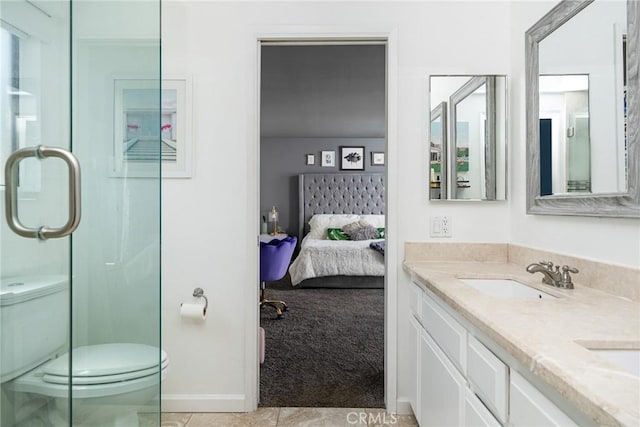 bathroom featuring tile patterned floors, a shower with door, vanity, and toilet