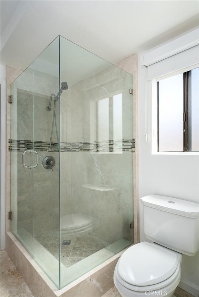 bathroom featuring toilet and an enclosed shower