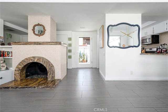 unfurnished living room with dark tile patterned flooring