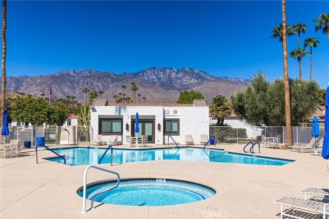 view of pool with a patio area, a mountain view, and a hot tub