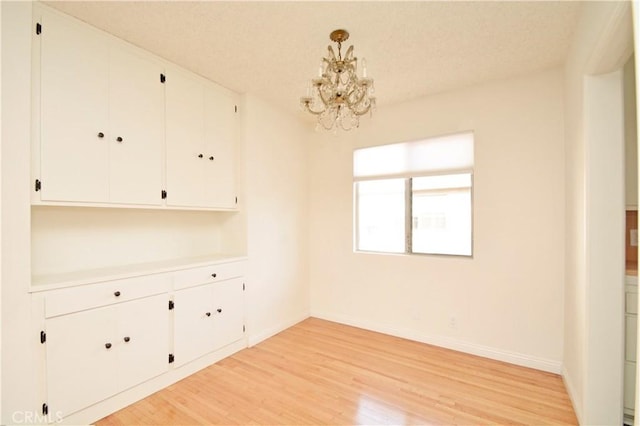 interior space featuring an inviting chandelier and light hardwood / wood-style floors