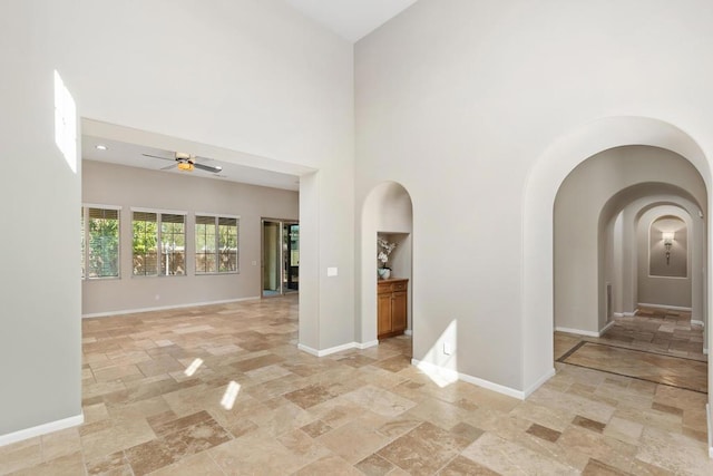 spare room with ceiling fan and a towering ceiling