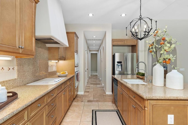 kitchen with light stone countertops, appliances with stainless steel finishes, an inviting chandelier, sink, and custom range hood