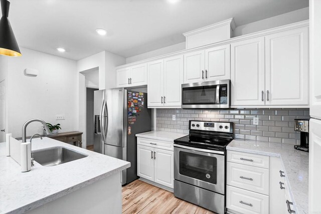 kitchen featuring appliances with stainless steel finishes, sink, and white cabinetry