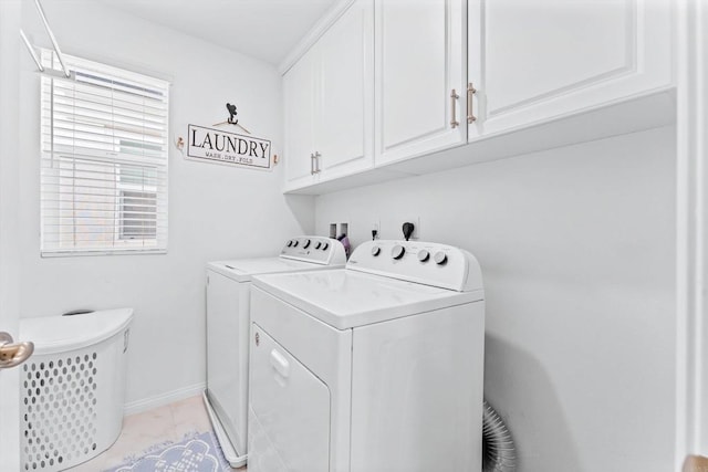 washroom featuring light tile patterned flooring, washing machine and clothes dryer, and cabinets