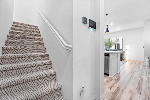 staircase with hardwood / wood-style floors