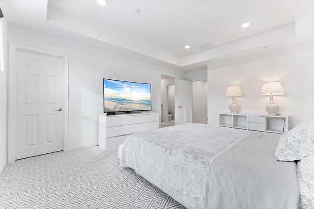 carpeted bedroom featuring a tray ceiling