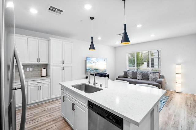 kitchen with stainless steel appliances, white cabinetry, and sink