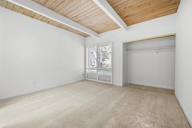 unfurnished bedroom with light carpet, lofted ceiling with beams, a closet, and wooden ceiling