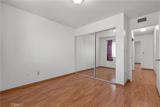 unfurnished bedroom with hardwood / wood-style flooring and a closet