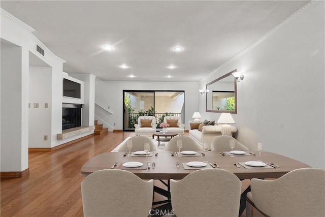 dining space featuring light hardwood / wood-style floors and crown molding