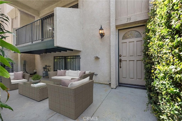 view of exterior entry with a balcony and outdoor lounge area