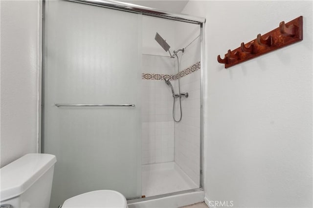 bathroom featuring toilet and walk in shower