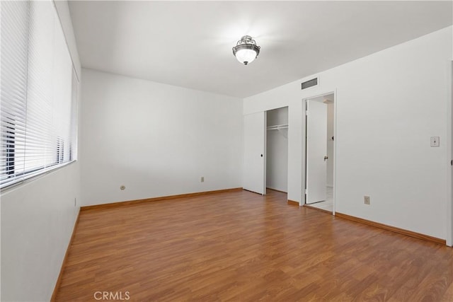 unfurnished bedroom featuring a closet and hardwood / wood-style floors