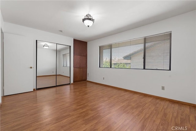 unfurnished bedroom featuring light wood-type flooring and a closet