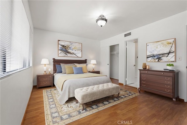 bedroom with dark hardwood / wood-style floors and a closet