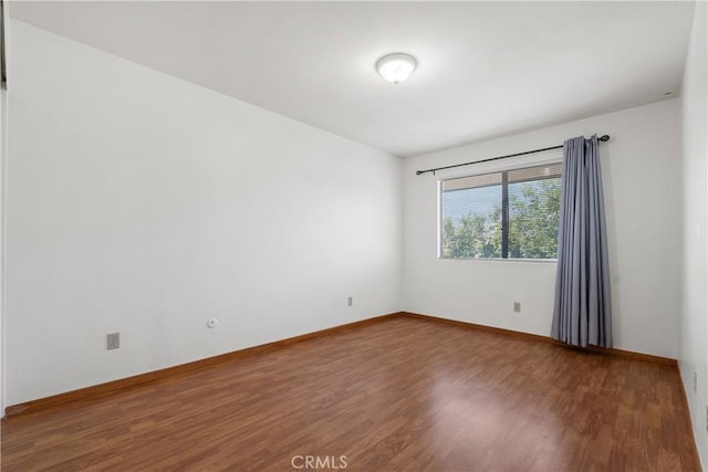 spare room featuring wood-type flooring