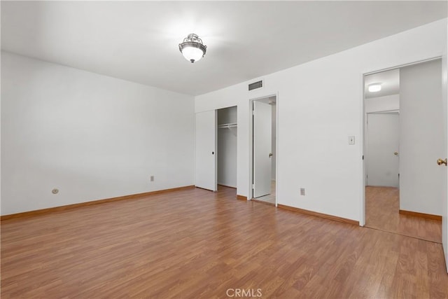 unfurnished bedroom with wood-type flooring and a closet