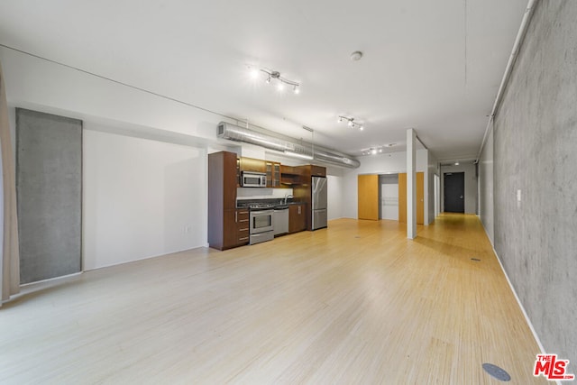 unfurnished living room featuring light wood-type flooring and sink