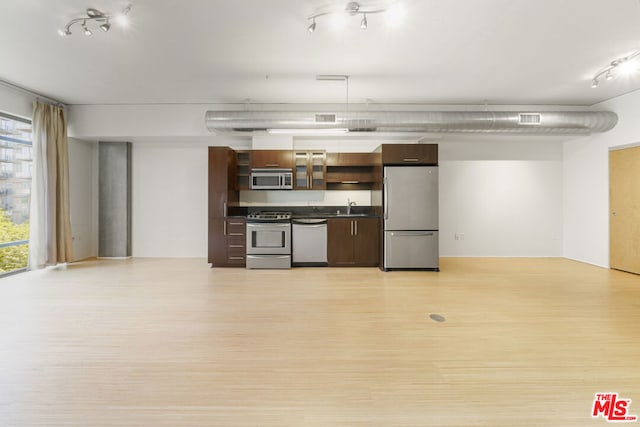 kitchen with a wealth of natural light, appliances with stainless steel finishes, sink, and light hardwood / wood-style flooring