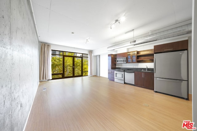 kitchen with sink, appliances with stainless steel finishes, and light hardwood / wood-style flooring