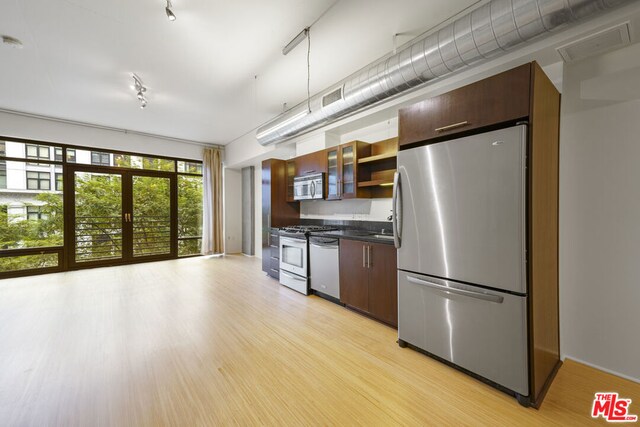 kitchen featuring plenty of natural light, sink, stainless steel appliances, and light hardwood / wood-style floors