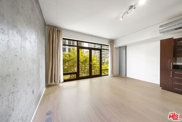 spare room with light hardwood / wood-style floors and french doors