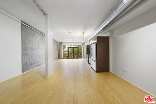 unfurnished room with french doors and light wood-type flooring