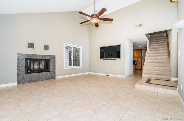 unfurnished living room with ceiling fan, light tile patterned flooring, and high vaulted ceiling