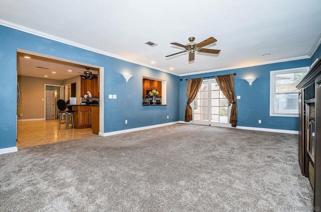 unfurnished living room featuring a wealth of natural light, carpet, crown molding, and ceiling fan